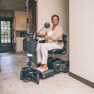 Woman coming around corner in house on mobility scooter