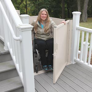 Woman using wheelchair exiting on deck from vertical platform lift