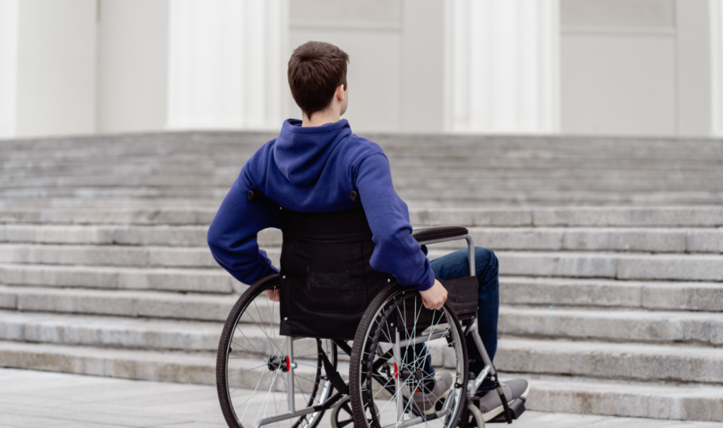 Man in wheelchair facing stairs