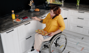 Woman in wheelchair fixing food in kitchen